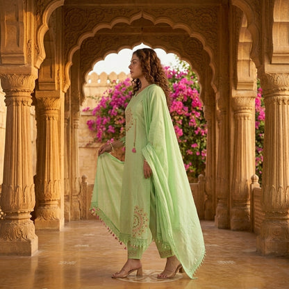 Side profile of mint green cotton kurta set with mandala mirror work and pink tassels, bougainvillea and palace arches background - Jagranee