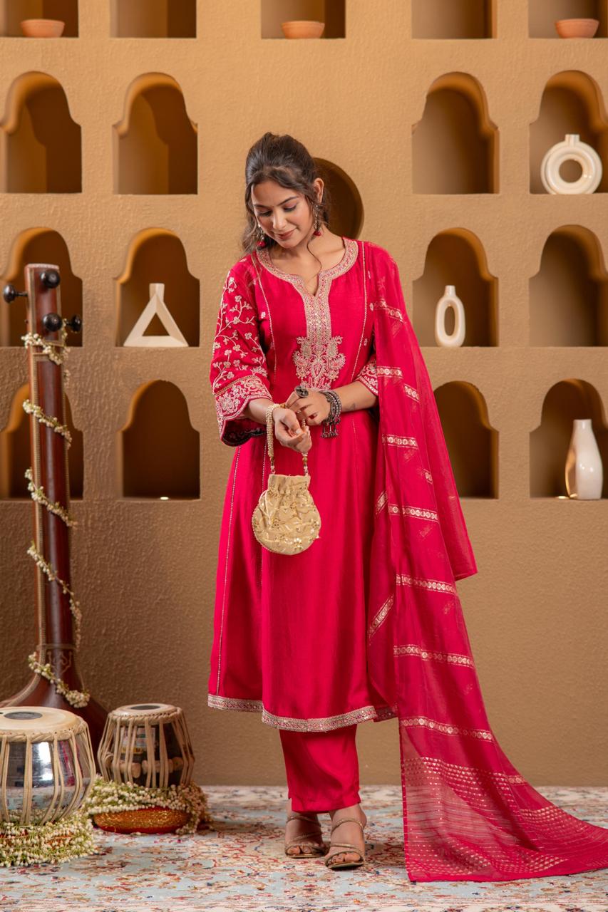 Rani pink embroidered Viscose Silk kurta set with gold zari striped dupatta, front view holding gold potli bag - Jagranee