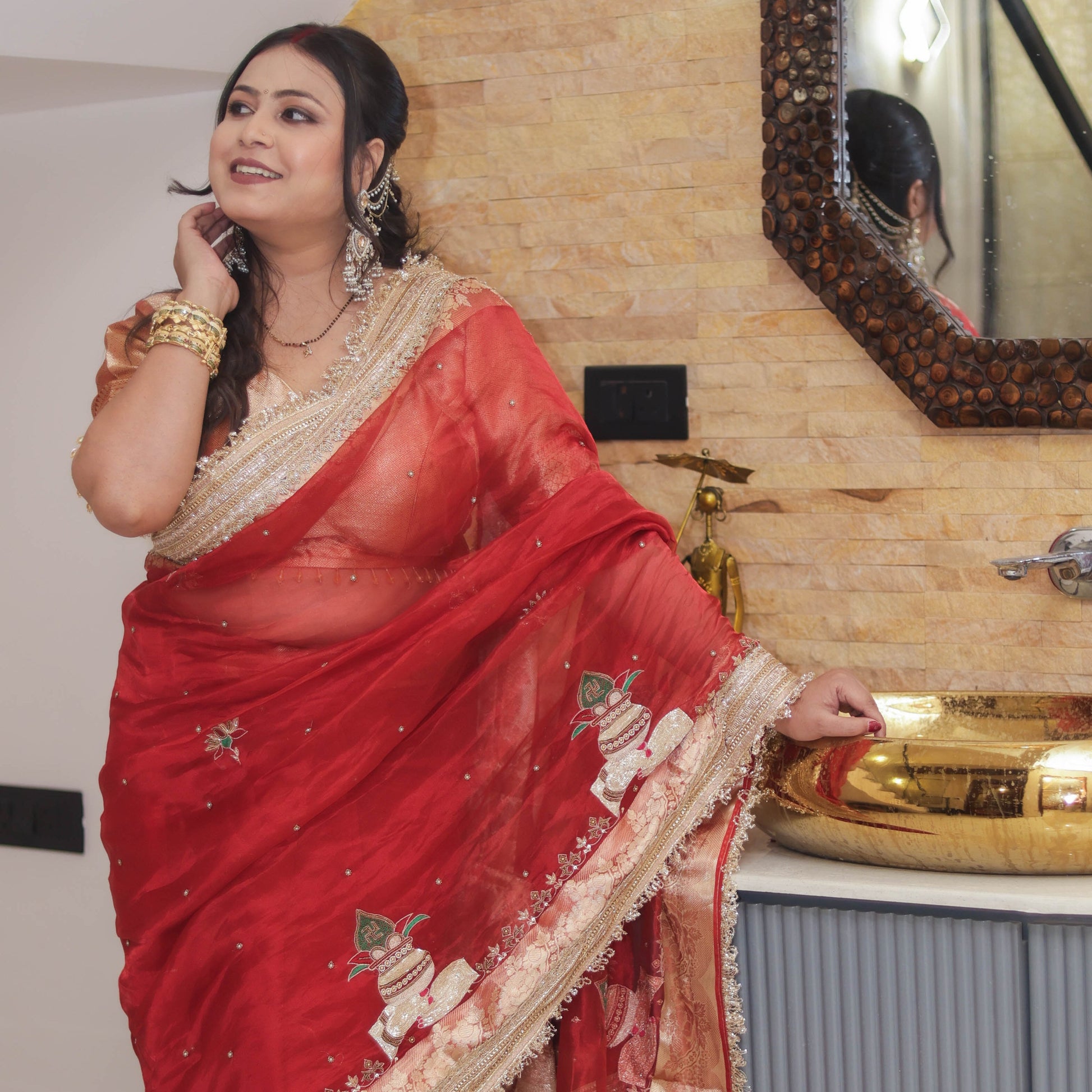 Woman wearing red tissue organza saree with pearl embellishments and gold brocade pallu, gold brocade blouse visible - Jagranee
