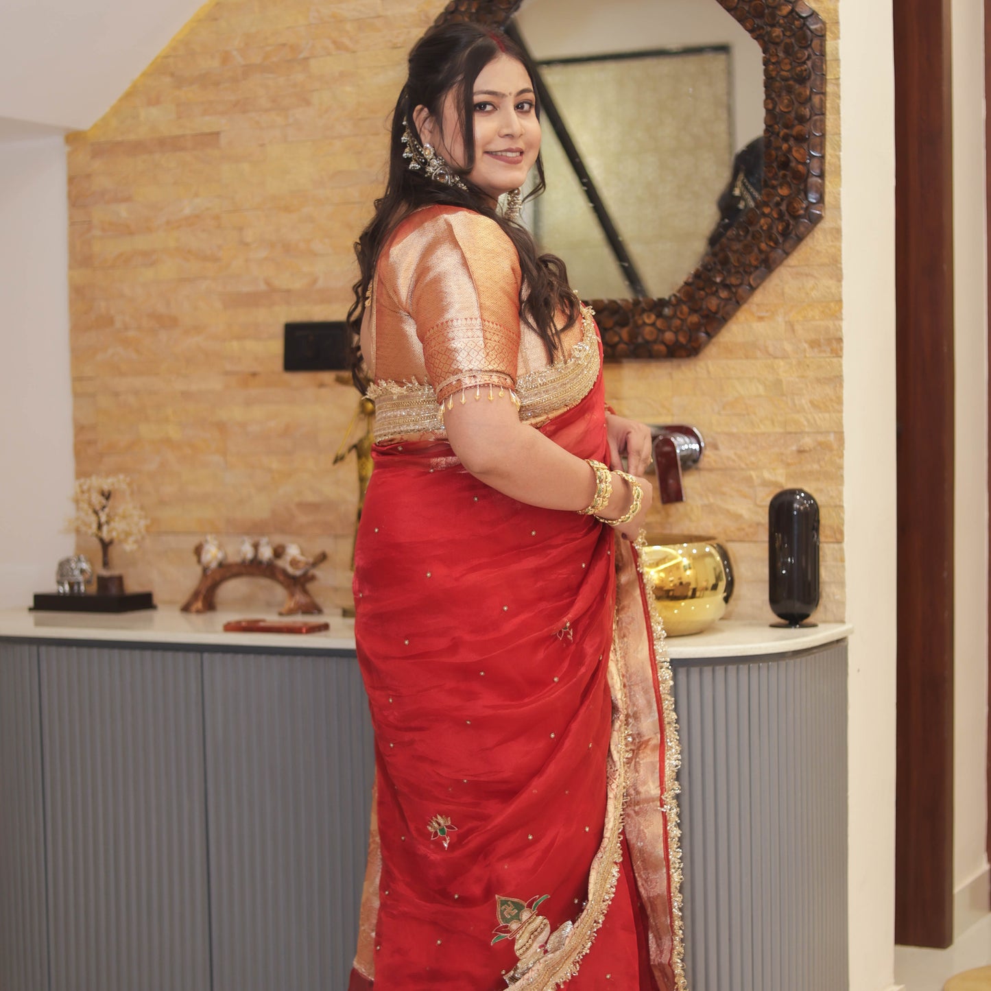 Back view of red tissue organza saree showing gold brocade blouse and embroidered kalash motifs with pearl work - Jagranee