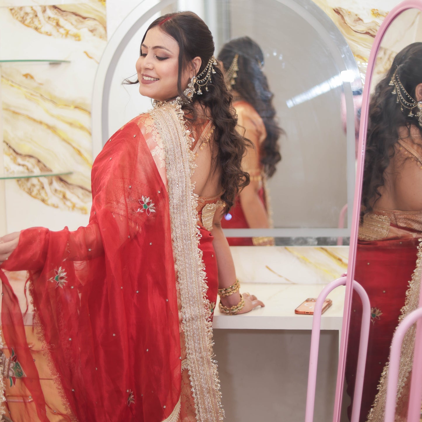 Mirror pose of red tissue organza saree with gold brocade pallu, pearl embellishments and gold lace fringe trim - Jagranee
