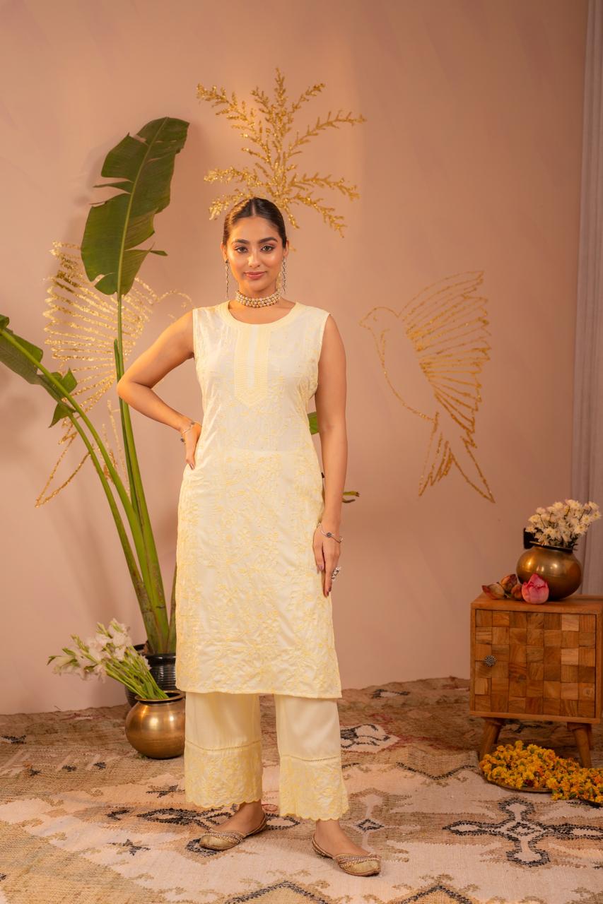 Woman wearing lemon yellow chikankari embroidered pure cotton sleeveless kurta set, front facing full body - Jagranee