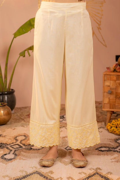 Close-up of lemon yellow embroidered palazzo pants with scalloped hem border and ladder lace detail - Jagranee